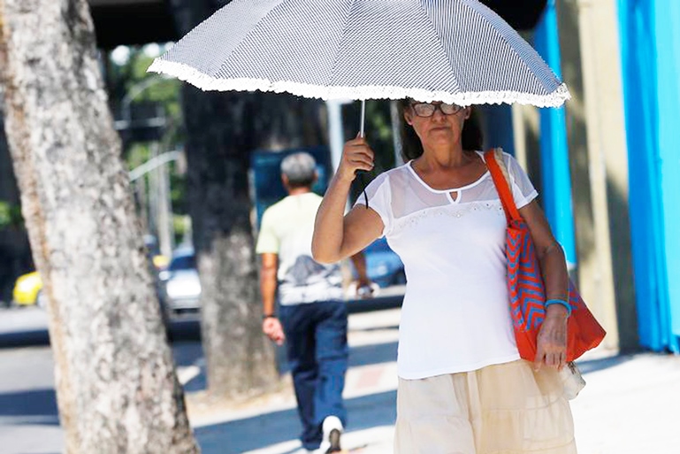 Mulher usa sombrinha para se proteger do forte calor - Divulgação/Agência Brasil