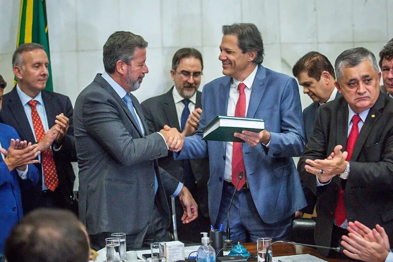 O presidente da Câmara, Arthur Lira, recebendo o texto das mãos do ministro da Fazenda, Fernando Haddad - Foto: Reprodução/ Governo Federal