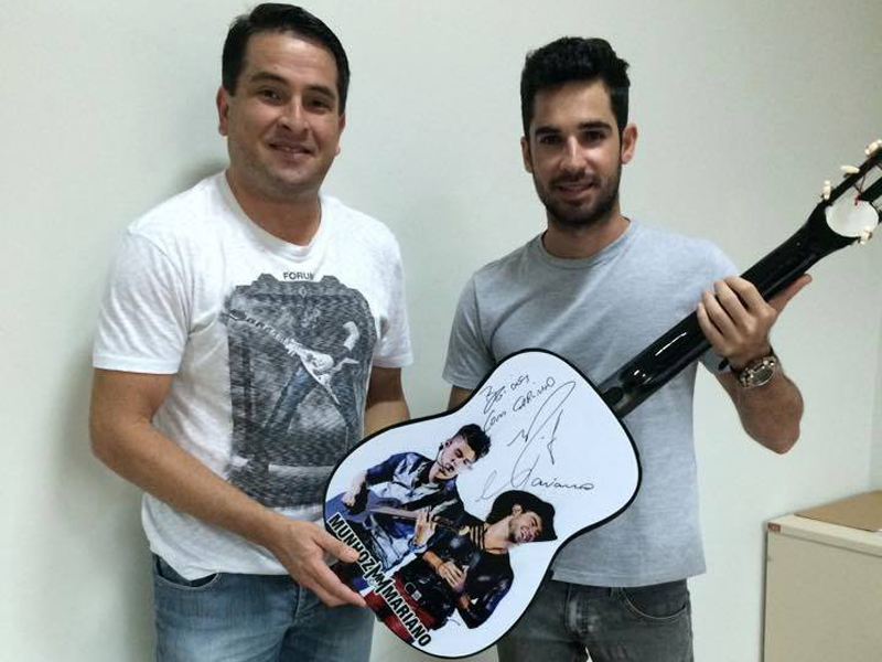 Bruno entrega o violão que será leiloado nas mãos de Marlan, da Apae - Divulgação/Facebook