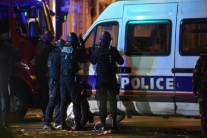 Policiais franceses vigiam passagem de carro, em rua próxima ao local do atentado - Agência Lusa
