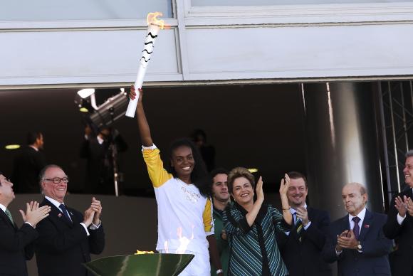 A jogadora de vôlei Fabiana Claudino, bicampeã olímpica (2008 e 2012), recebe a Tocha Olímpica das mãos da presidenta Dilma. Presidenta diz que participantes serão bem recebidos no Brasil - Marcelo Camargo/Agência Brasil