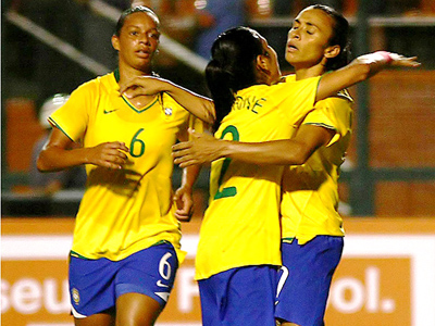 Marta (dir.) é abraçada ao marcar mais um gol para o Brasil -