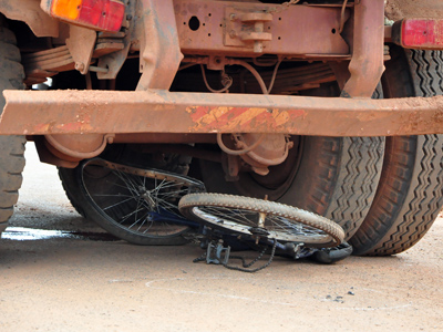 A bicicleta ficou presa entre os pneus do caminhão -