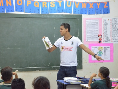 Professor Cleiton de Melo Sousa, realizando leitura para alunos do Ensino Fundamental no projeto Leitura Compartilhada -