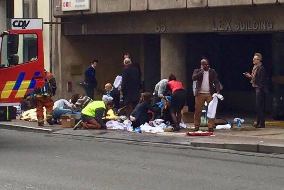 Equipes de emergência socorrem feridos em frente à estação Maelbeek do metrô, em Bruxelas - Agência Lusa