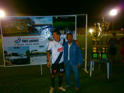 Nenê Veloso (dir.) entrega um troféu -