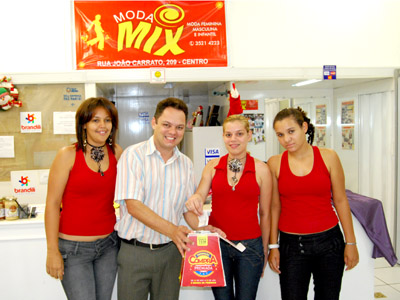 O proprietário da loja Moda Mix, Júlio César Suzuki, realiza o sorteio com as suas vendedoras -