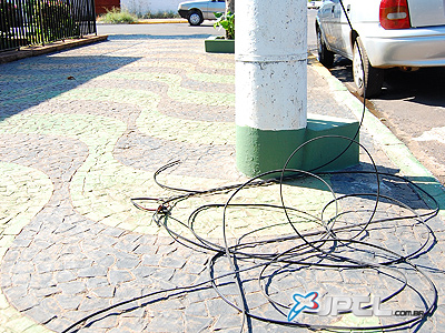 Fio de telefone está jogado na calçada da rua Monir Thomé há mais de duas semanas -