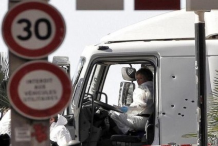 Policiais investigam a cabine do motorista do caminhão que se jogou sobre uma multidão de pessoas que comemoravam a data nacional da França, em Nice - Alberto Estevez/Pool/Agência Lusa
