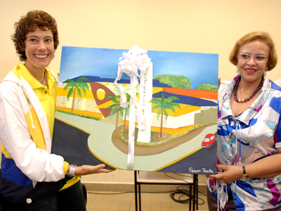 Adriana Behar recebe das mãos da secretária de Assistência Social Maria Lúcia Firmino uma pintura da fachada do Crase -