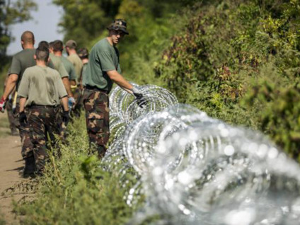 Soldados húngaros montam cerca de arame farpado ao Sul do país, na fronteira com a Croácia  - Balazs Mohai/EPA/Agência Lusa