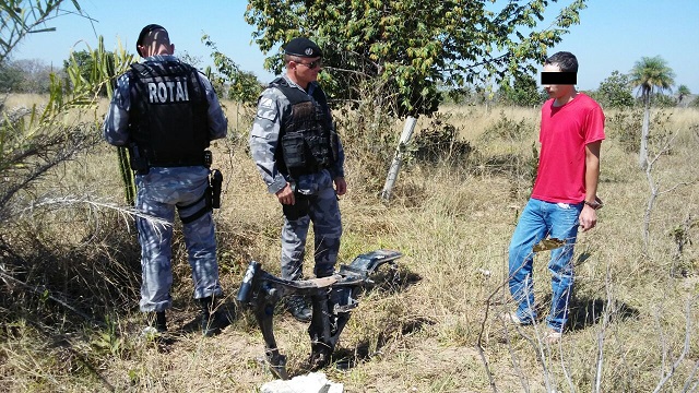 Policiais e um dos presos observam peças de motos escondidas em matagal - Celso Daniel/TVC