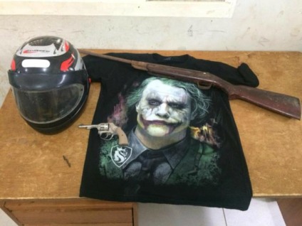A polícia apreendeu um revólver ,uma espingarda e uma camiseta preta com desenho do coringa,