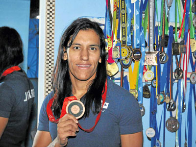 Michelle Ferreira mostra a medalha de bronze conquistada, há quatro anos -