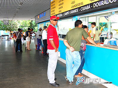 Os guichês das empresas de ônibus na rodoviária estavam repletos de pessoas comprando passagens -