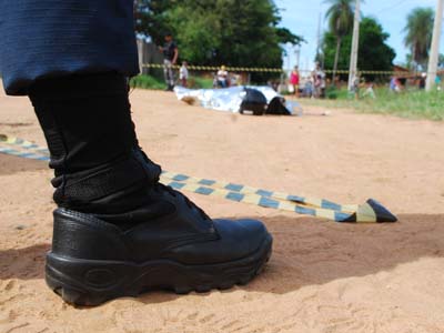 Na cena do crime, populares observam o trabalho da polícia -