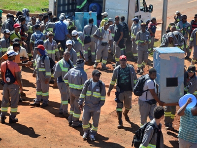 Os trabalhadores estão de braços cruzados em frente ao canteiro de obras -