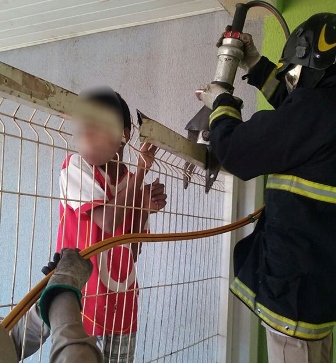 Menino havia ficado preso após tentar pular a grade - Divulgação/Corpo de Bombeiros 