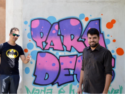 Orientadores do projeto, diante de quadro produzido por internos da Unei - Divulgação/Unei