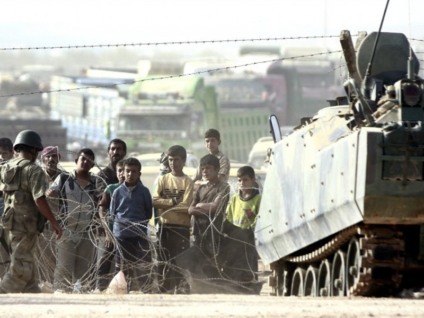 Refugiados sírios na fronteira com a Turquia fogem de ataques do Estado Islâmico - Agência Lusa/Direitos Reservados