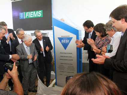 Convidados da Fiems observam José Paulo Rímoli descerrar placa da escola que leva seu nome