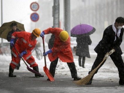 Trabalhadores da estação ferroviária empurrar a neve da rua em Yokohama, Japão, sábado, 8 de fevereiro, 2014. - Arquivo/Radioshiga Trabalhadores da estação ferroviária empurrar a neve da rua em Yokohama, Japão, sábado, 8 de fevereiro, 2014. - Arquivo/Radioshiga