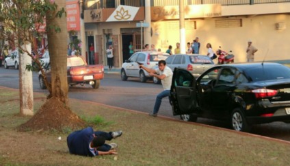 Atirador desceu de carro e fez os disparos; no chão, uma pessoa tenta se proteger - Reprodução/WhatsApp