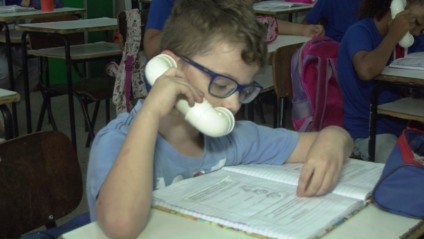 Alunos da Escola Municipal Olyntho Mancini usam o “sussurrofone” - Reprodução/TVC Alunos da Escola Municipal Olyntho Mancini usam o “sussurrofone” - Reprodução/TVC