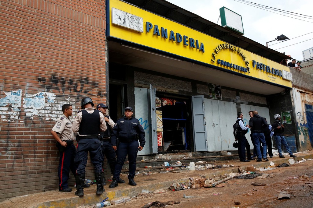 Policiais e investigadores em frente à padaria saqueada em Caracas - Divulgação/Reuters