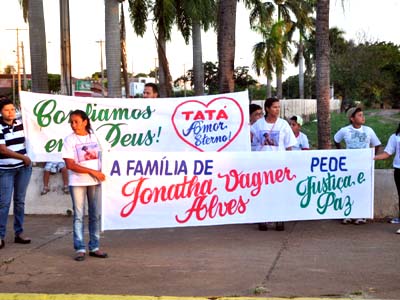 Familiares e amigos segurando faixas em protesto -