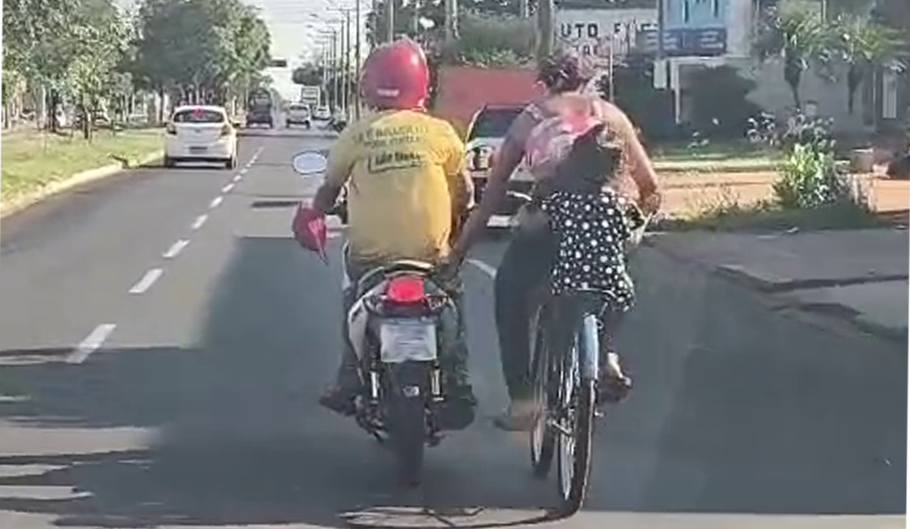 Ciclista foi flagrada pegando rabeira na traseira de moto em movimento.