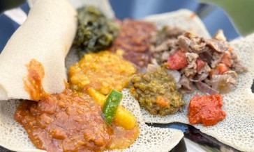 Um dos pratos mais emblemáticos é a injera, um pão achatado e esponjoso feito a partir do tef, o menor grão do mundo