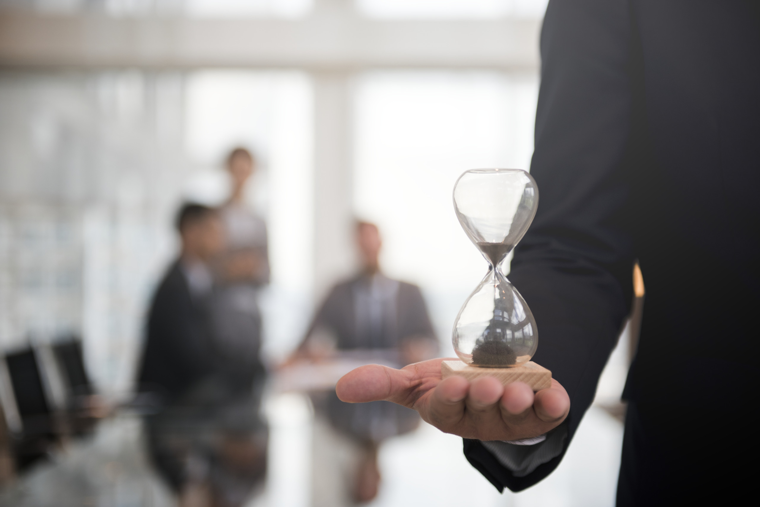 Businessman holding an hour glass, signifies the importance of being on time