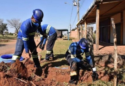Trabalhadores substituindo tubulações de amianto em via pública