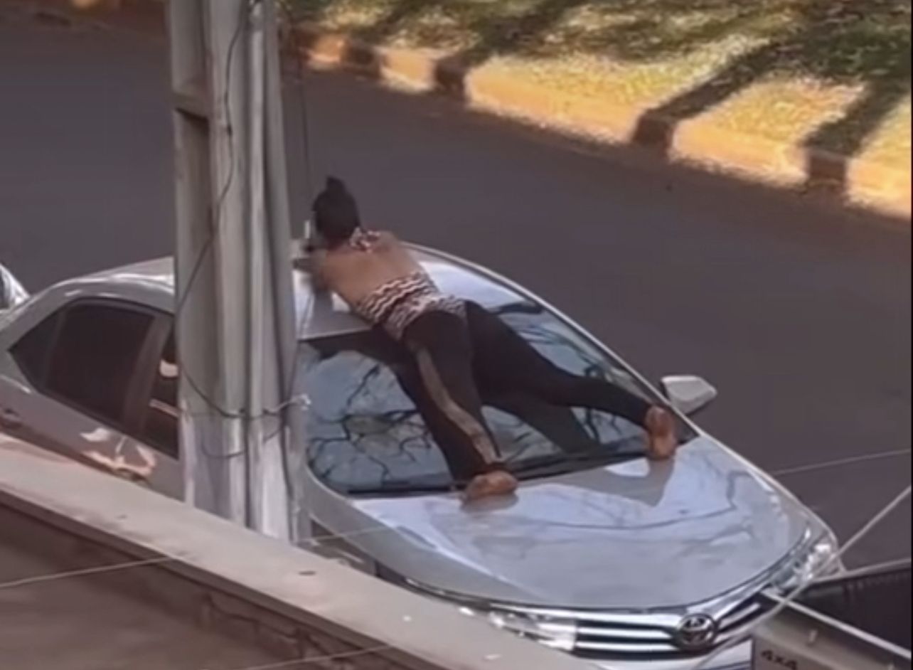 Vídeos da mulher foram divulgados nas redes sociais, mostrando que ela subiu em carros estacionados no centro de Dourados. (Reprodução)