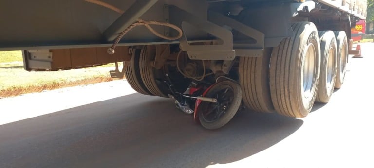 Moto vai parar debaixo de carreta e motociclista escapa ileso de grave acidente