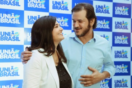 Rose Modesto em entrevista, com fundo institucional do Grupo RCN