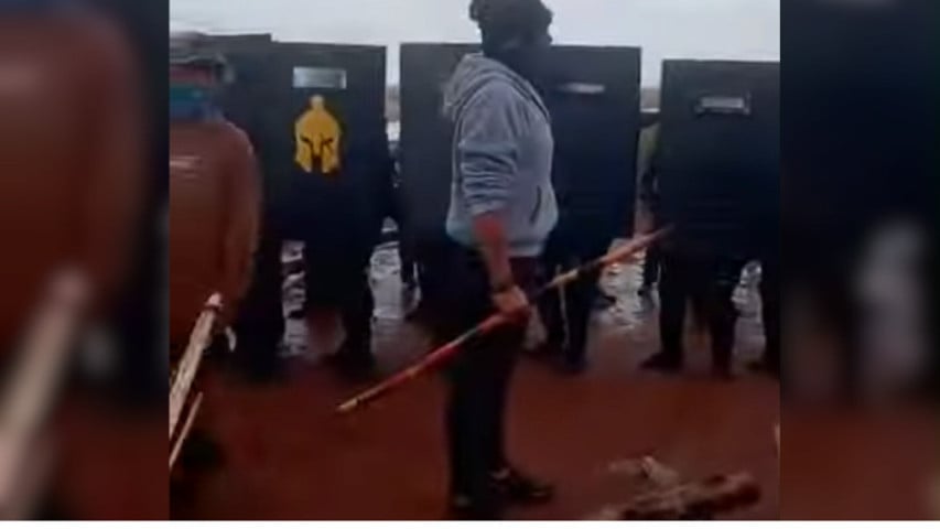 Policiais e manifestantes em área rural durante operação em disputa por terra em MS