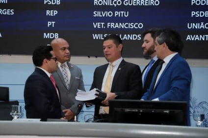 Plenário da Câmara Municipal de Campo Grande durante sessão, com vereadores em votação e painel eletrônico ao fundo