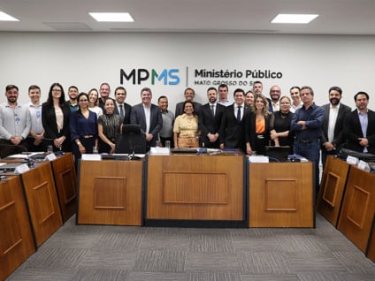 Reunião institucional sobre o acordo da Santa Casa, com documentos assinados e autoridades em mesa de trabalho, clima de urgência.