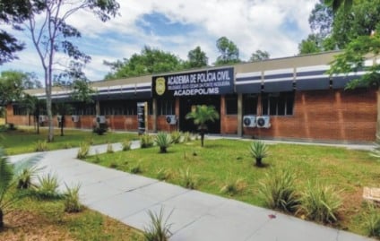 Fila de candidatos em ambiente institucional com documento de convocação e símbolo genérico de segurança pública ao fundo