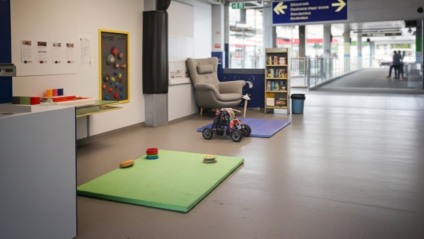 Sala tranquila com iluminação suave, itens táteis e poltrona confortável, simbolizando espaço de regulação sensorial em órgão público