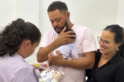 Profissional de saúde coletando amostra do teste do pezinho em recém-nascido, ambiente SUS