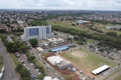 Fachada de hospital com planilha orçamentária e carimbo de suplementação