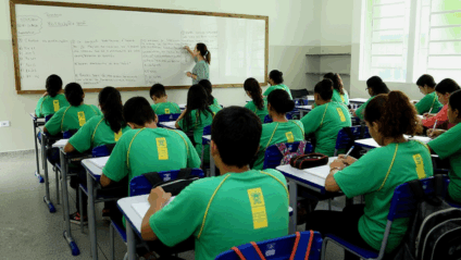 Sala de aula com quadro e lista de convocação de professores em primeiro plano
